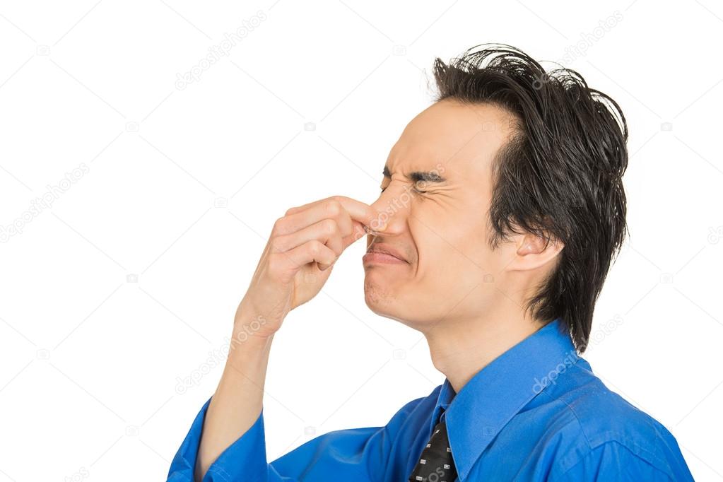 man disgust on his face pinches his nose, something stinks bad smell