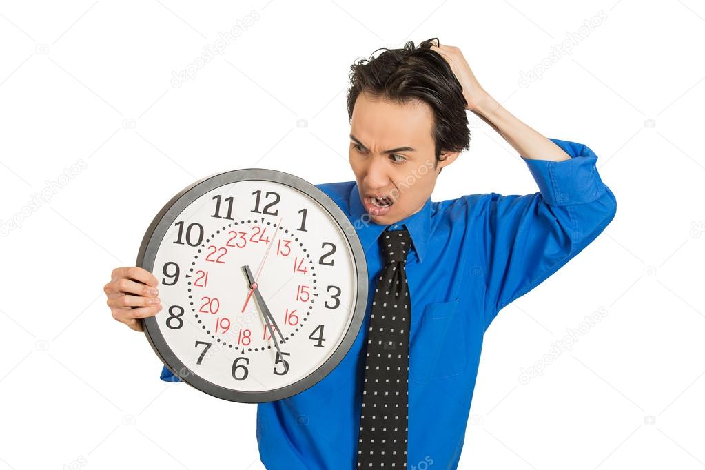 business man holding clock stressed, pressured by lack of time