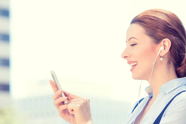 Woman with earphones holding using smart mobile phone — Stock Photo, Image