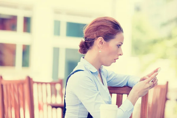 Mujer sorprendida leyendo el mensaje en su teléfono inteligente — Foto de Stock