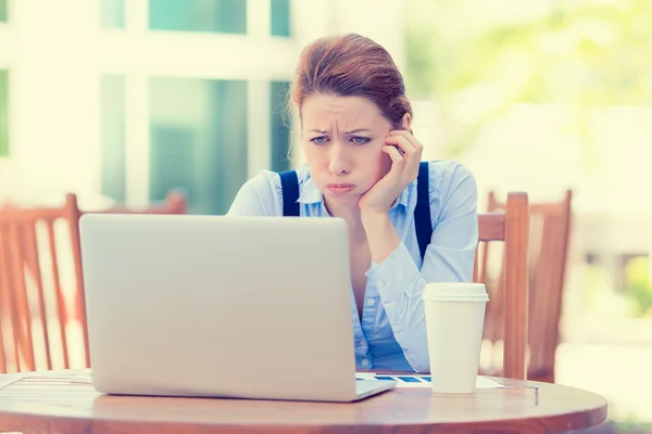 Scontento preoccupato donna d'affari seduto di fronte al computer portatile Immagine Stock