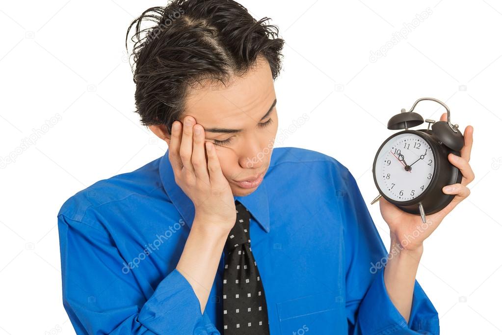 sleeping young man holding alarm clock