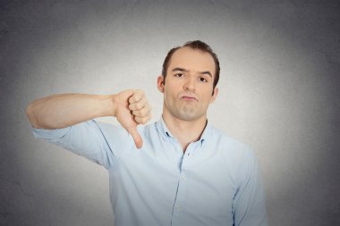 angry, unhappy, young handsome man showing thumbs down clipart