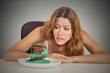 woman craving sugar sweet cookies but worried about weight gain clipart