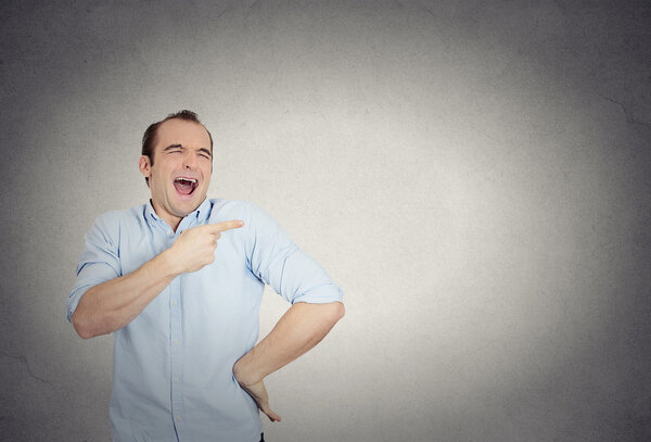 young man, laughing, pointing with finger, arms at someone