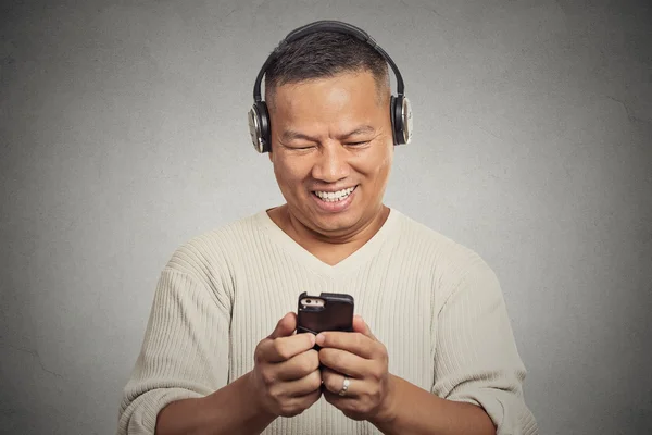 Uśmiechnięty mężczyzna młody słuchania muzyki na telefon komórkowy — Zdjęcie stockowe