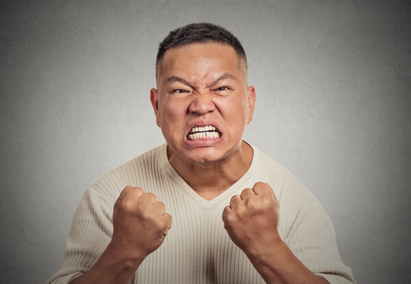 headshot angry man with open mouth fist up in air aggressive screaming