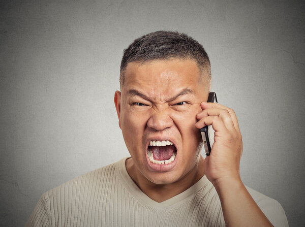 Angry middle aged man pissed off employee shouting while on phone