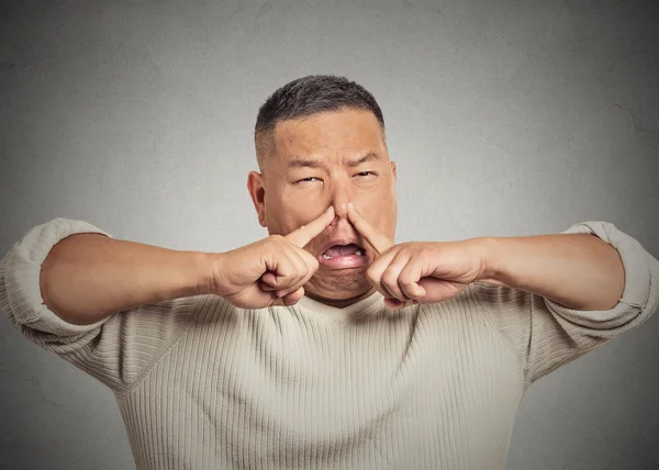 Headshot young man disgust on face, pinches nose something stinks — Stock Photo, Image