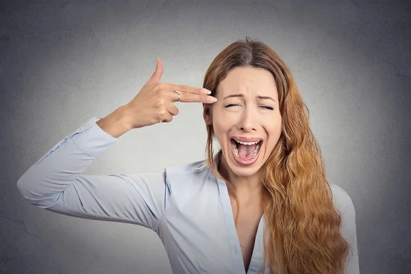 Stressed young woman with hand gun gesture screaming — Stock Photo, Image