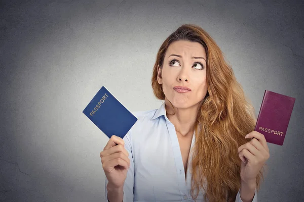 Vrouw met twee paspoorten verward gezicht expressie — Stockfoto