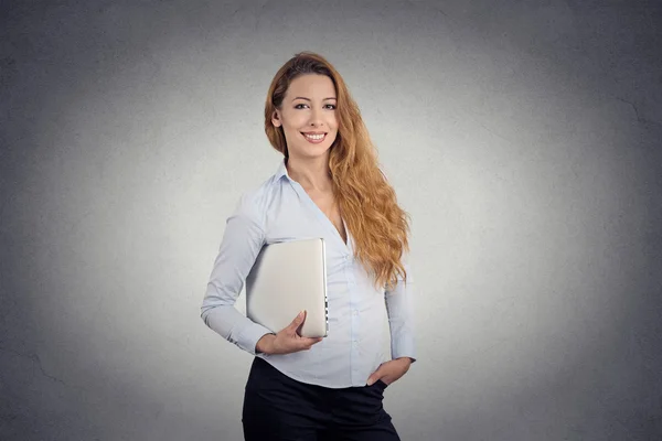 Mujer feliz sosteniendo portátil sonriendo de pie —  Fotos de Stock