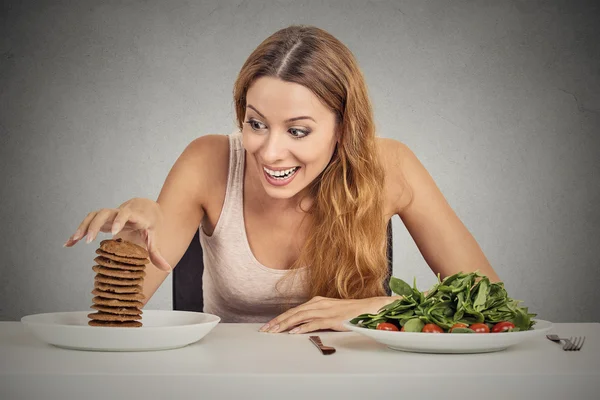 Vrouw beslissen om te eten van gezonde voeding of zoete cookies ze verlangen — Stockfoto