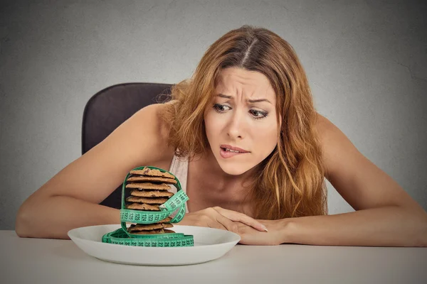 Vrouw verlangen suiker zoete koekjes maar bezorgd over de aanwinst van het gewicht — Stockfoto