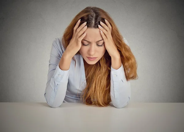 Verzweifelte junge Geschäftsfrau lehnt an einem Schreibtisch — Stockfoto