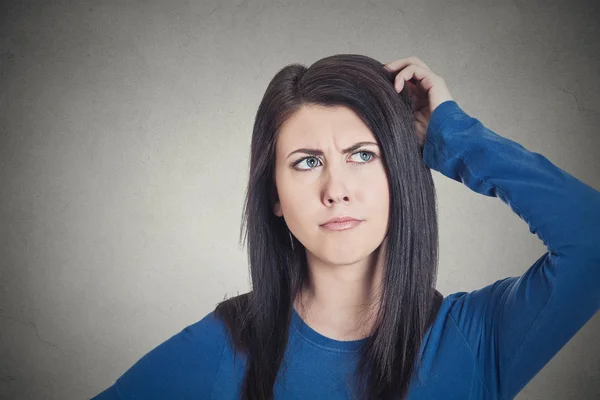 Frau kratzt sich am Kopf, denkt tagträumend an etwas — Stockfoto