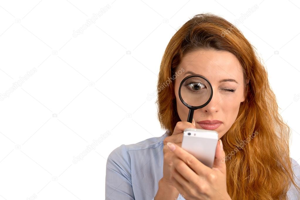 woman looking through magnifying glass at smart phone