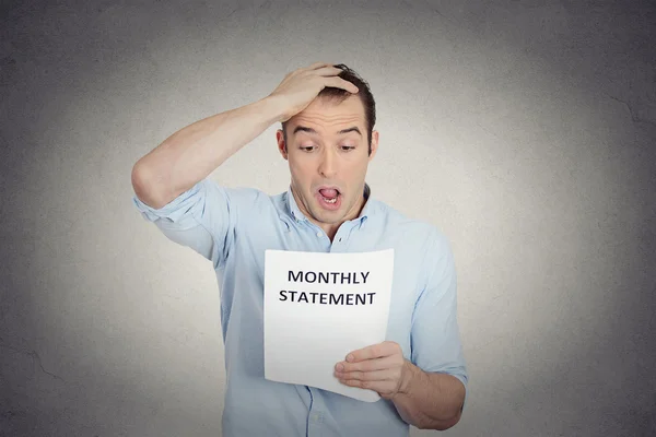Shocked funny looking man disgusted at his corporate monthly statement — Stock Photo, Image