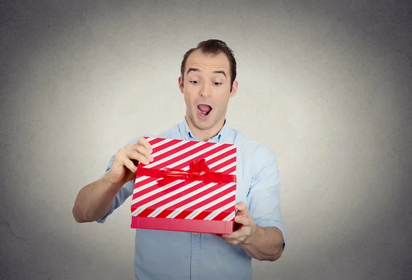 Feliz super emocionado joven sorprendido a punto de abrir desenvolver caja de regalo roja — Foto de Stock