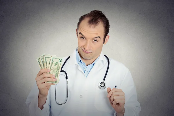 Grumpy greedy miserly health care professional holding money — Stock Photo, Image