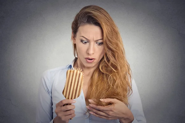 Mujer peinando sorprendida ella está perdiendo el pelo, retrocediendo la línea del pelo — Foto de Stock