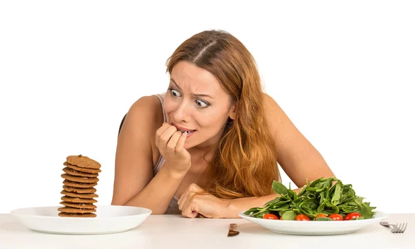 Mulher decidir se quer comer alimentos saudáveis ou biscoitos doces — Fotografia de Stock