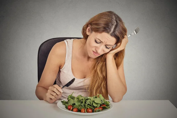 Triste descontente jovem mulher comendo salada — Fotografia de Stock