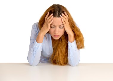 Depressed business woman leaning on a desk looking down 