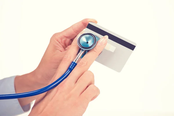Woman hands holding listening credit card with stethoscope — Stock Photo, Image