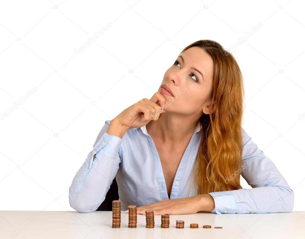 business woman corporate executive sitting at table with growing stack of coins