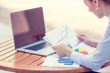 Kadın yatırım danışmanı şirketin yıllık mali raporunu analiz ediyor. 