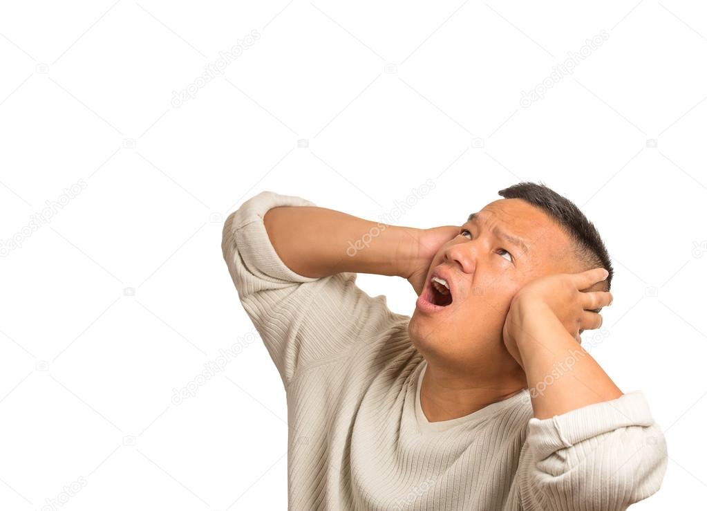 unhappy stressed man covering his ears looking up