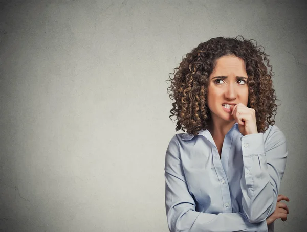 Nervous looking woman biting her fingernails craving something — Stock Photo, Image