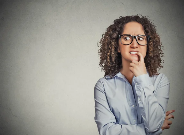 Nervous woman with glasses biting her fingernails craving for something — Stock Photo, Image