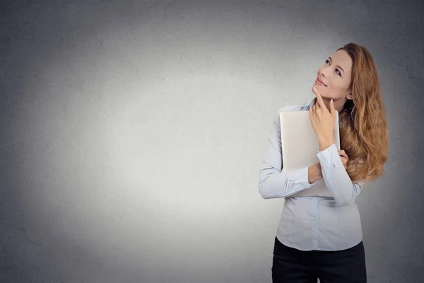 Happy beautiful woman holding laptop thinking looking up — Stock Photo, Image