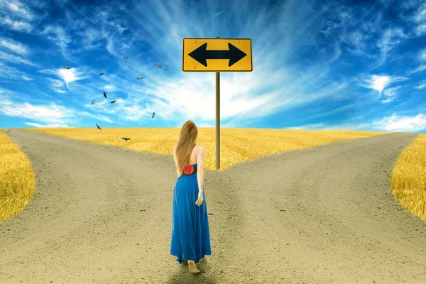 Young woman standing in front of two roads — Stock Photo, Image