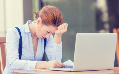 stressed displeased worried business woman sitting in front of laptop computer  clipart