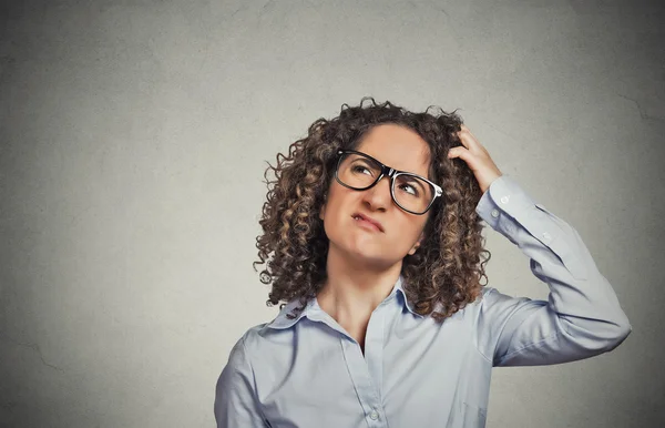 Donna con gli occhiali graffiare la testa, pensando confuso — Foto Stock