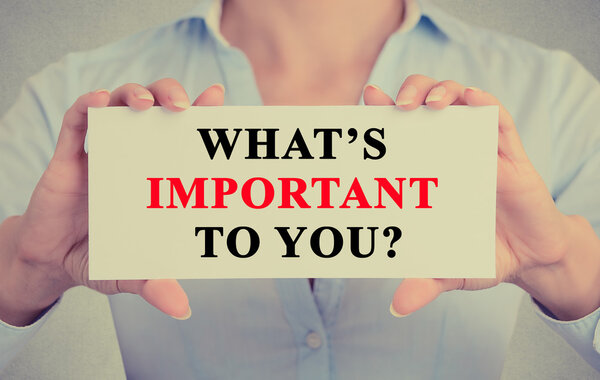 Businesswoman hands holding sign with What is important to you ? question