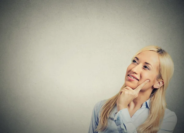 Happy beautiful woman thinking looking up isolated grey wall background — Stock Photo, Image