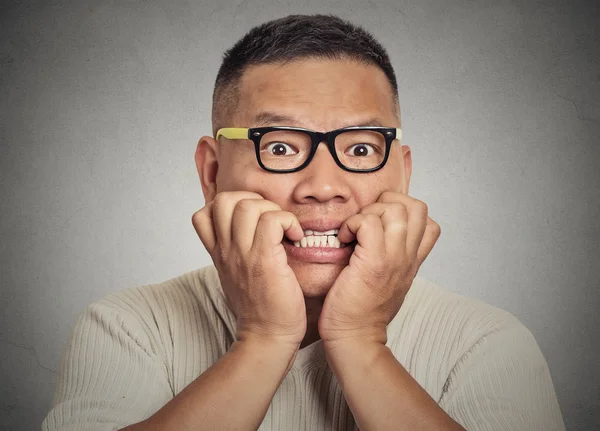 Headshot nerdy guy with glasses biting his nails looking anxious craving — Stock Photo, Image