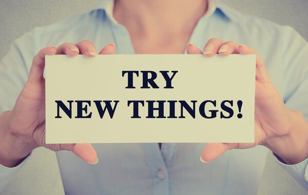businesswoman hands holding card sign with try new things message