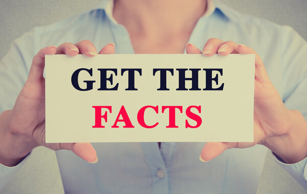 Businesswoman hands holding card sign with get the facts message 