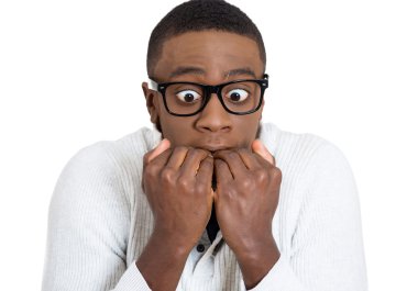Shy unhappy guy with black glasses biting his nails looking scared  clipart