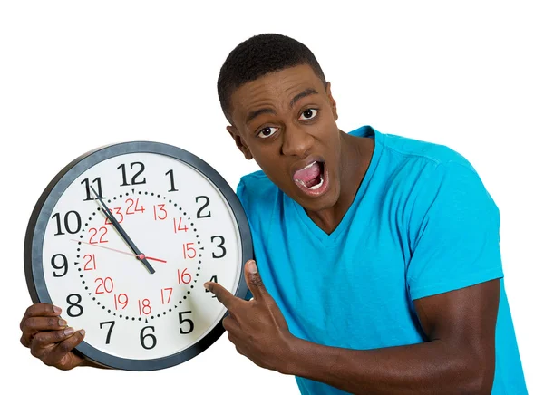 Man holding wall clock, stressed biting fingernails pressured by lack of time — Stock Photo, Image