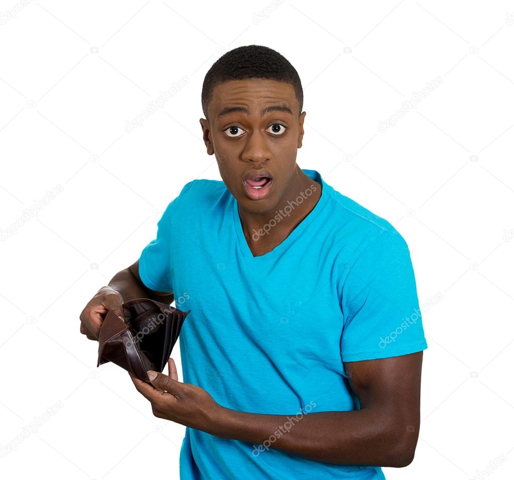 Broke young man showing empty wallet