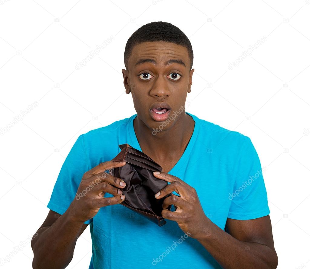 Broke young man showing empty wallet