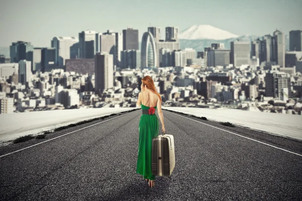 Vrouw met koffer lopen op weg naar stad praten over telefoon — Stockfoto