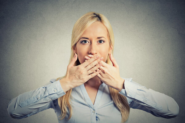 woman covering closed mouth with hands