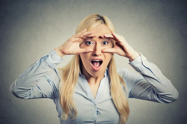 Surprised woman peeking looking through binoculars — Stock Photo, Image